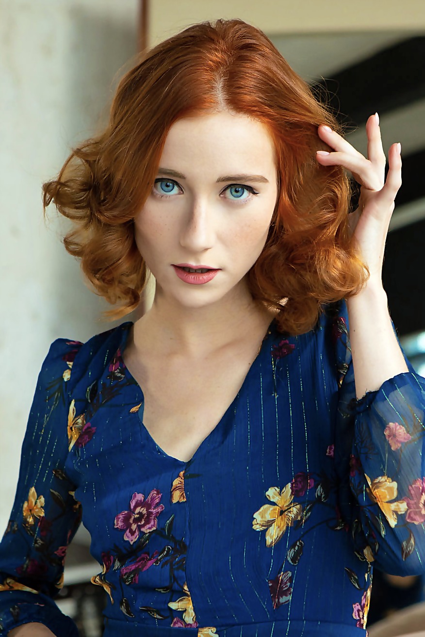 Redhead in a Blue Floral Dress on Soft Bedding